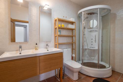 a bathroom with a shower and a sink and a toilet at Casa Curumbico in Almuñécar