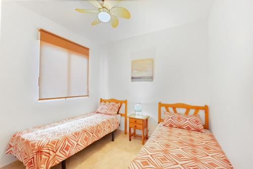 a bedroom with two beds and a ceiling fan at Good Atmosphere in Orihuela