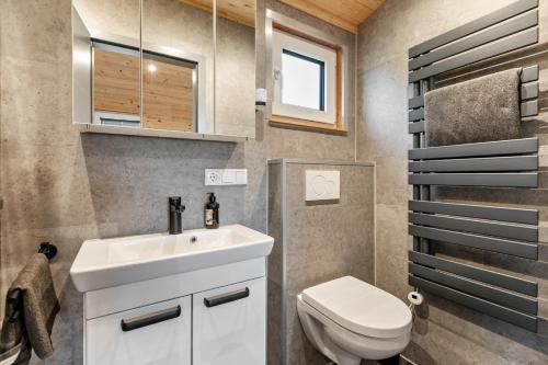 a bathroom with a white sink and a toilet at Naturpur Tinyhouse in Osterrade