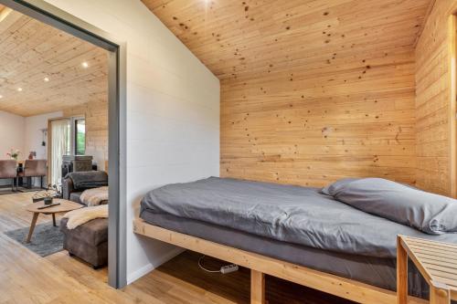 a bedroom with a bed and a wooden wall at Naturpur Tinyhouse in Osterrade
