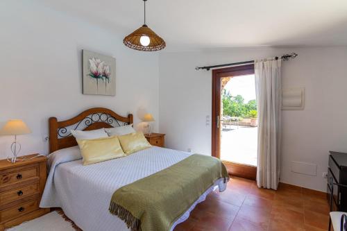 a bedroom with a bed and a sliding glass door at Hortet in Campos