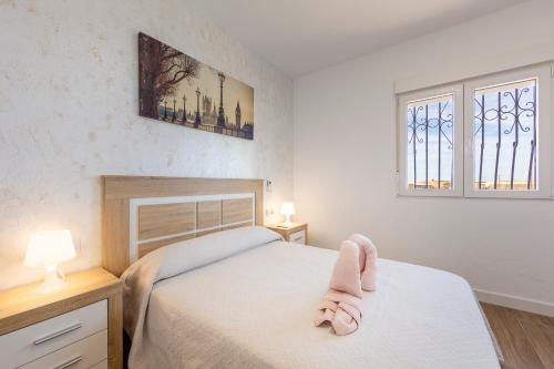 a bedroom with a bed and two windows at La palmera in Níjar