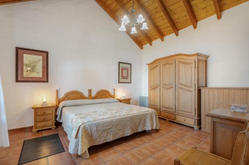 a bedroom with a bed and a wooden cabinet at El Ciruelo in Valverde