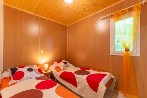 a bedroom with two beds and a window at Maison Chloé - Mas Lachamp in Gravières