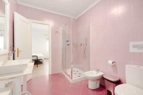 a pink bathroom with a shower and a toilet at Casa Miró in Humilladero