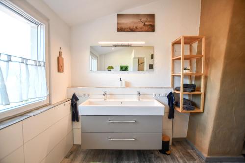 a bathroom with a white sink and a mirror at Ferienwohnung zum Krummholz in Fischerbach
