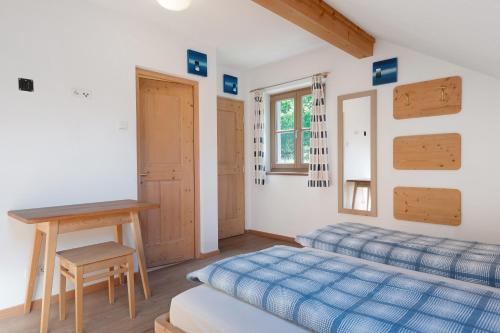 a bedroom with two beds and a table and a desk at Rielingerhof in Collalbo