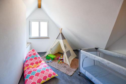 a childs room with a tent and a bed at Ferienwohnung zum Krummholz in Fischerbach