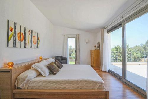 a bedroom with a bed and a large window at Caleu in Binissalem