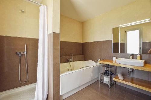 a bathroom with a tub and a shower and a sink at Caleu in Binissalem