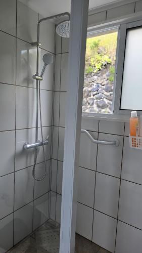 a shower in a bathroom with a window at Baía do Porto das Lajes in Lajes das Flores