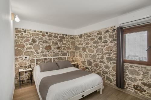 a bedroom with a bed and a stone wall at El Blanquizal A in San Nicolás