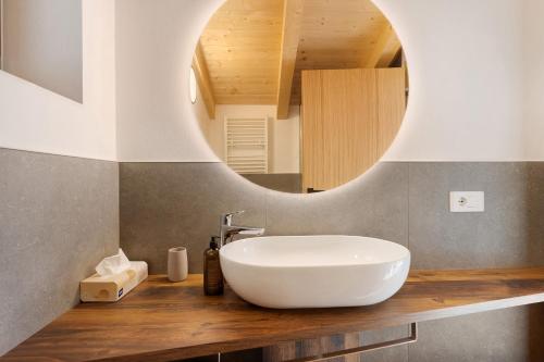 a bathroom with a white sink and a mirror at Villa Helena - Panorama Dolomiti in Cavalese