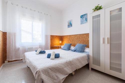 a bedroom with a large bed with blue pillows on it at Bruc Apartment Beach in Canet de Mar