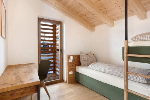 a bedroom with a bunk bed and a desk at Villa Helena - Panorama Dolomiti in Cavalese