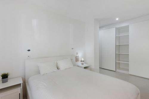 a white bedroom with a large white bed at T2 Furadouro 30m from the beach in Ovar