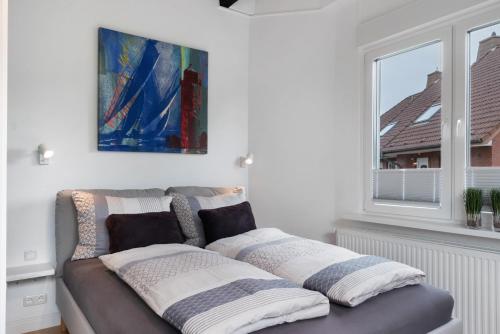 a couch with pillows on it in a room with a window at Ferienwohnung Alte Liebe in Cuxhaven