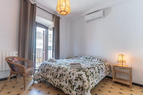 a bedroom with a bed and a chair and a window at Casa Blanca in Estepona