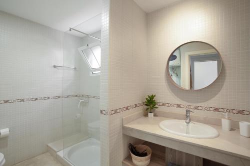 a white bathroom with a sink and a mirror at Mangueros Suite 18 Puerto de Mogán in Puerto de Mogán