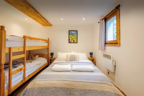 a bedroom with two bunk beds and a window at Chalet Chocolat - 10 pers - Châtel in Châtel