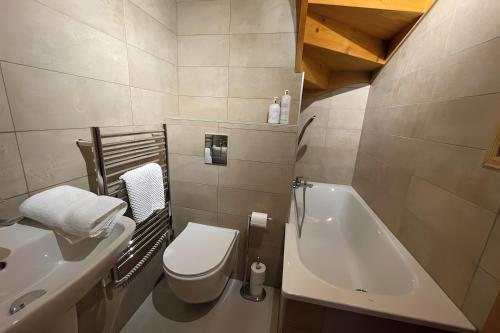 a bathroom with a toilet and a sink and a tub at Chalet Chocolat - 10 pers - Châtel in Châtel