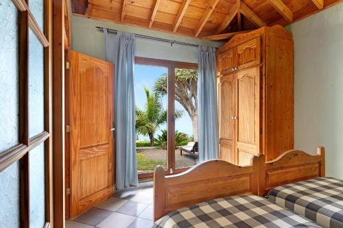 a bedroom with a bed and a large window at Villa Gorgonia in Tijarafe