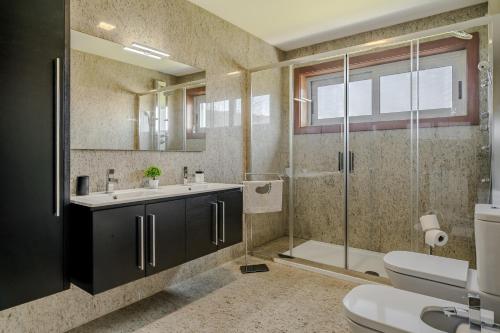 a bathroom with a toilet and a sink and a shower at Casa Do Chino in Esposende