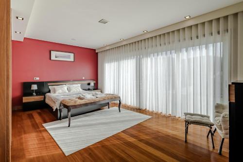 a bedroom with a bed and a red wall at Casa Do Chino in Esposende