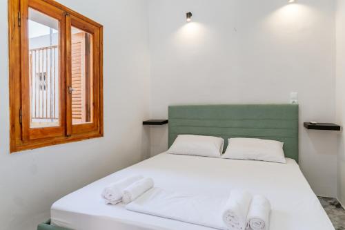 ein Schlafzimmer mit einem Bett, auf dem Handtücher liegen in der Unterkunft Azure Nest in Néa Péramos