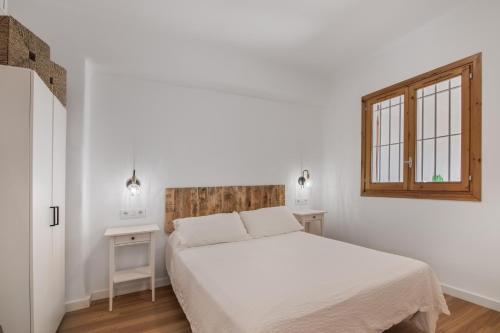 a white bedroom with a bed and a window at Primera Linea en Matalascañas in Matalascañas