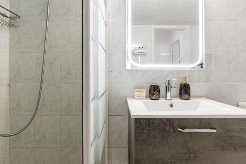 ein Badezimmer mit Waschbecken und Dusche in der Unterkunft Azure Nest in Néa Péramos