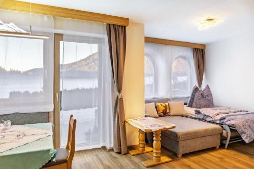 a room with a couch and a bed and a window at Ferienwohnung Paula in Leutasch