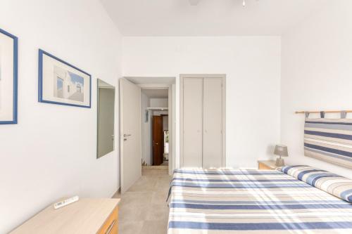 a bedroom with a bed with blue and white sheets at Franza 2 in Torre San Giovanni Ugento