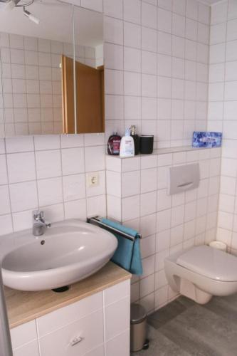a white bathroom with a sink and a toilet at Ferienwohnung Talblick in Meßstetten