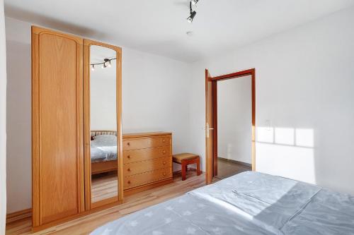a bedroom with a bed and a dresser with a mirror at Ferienwohnung Gaberle in Balve