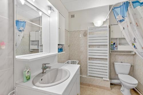 a white bathroom with a sink and a toilet at Orciéres Village in Orcières