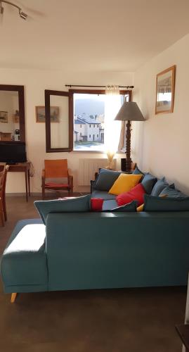 a living room with a blue couch with colorful pillows at Appartement Roc Sol I Neou in Puyvalador