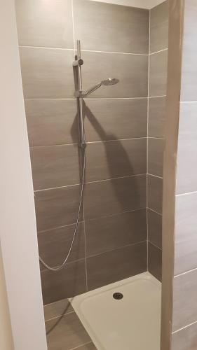 a shower with a hose in a bathroom at Appartement Roc Sol I Neou in Puyvalador
