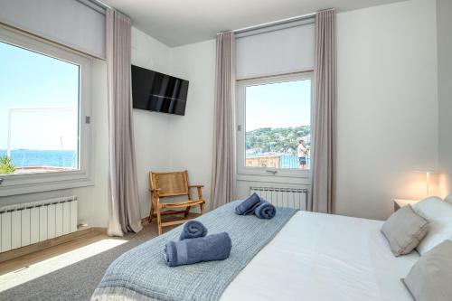 a bedroom with a large bed with blue towels on it at Casa dins el Mar en Calella in Calella de Palafrugell