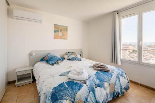 a bedroom with a bed with a blue and white bedspread at Résidence du lac de Jouarres in Homps
