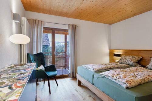 a bedroom with a bed and a desk with a chair at Ländliche Ferienwohnungen in Öhningen