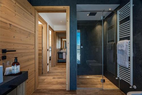 a bathroom with a shower and a glass door at Arnica Alpin Lodge in Cavedago