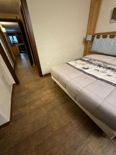 a bedroom with a bed and a wooden floor at Maison Maribel in Pré-Saint-Didier