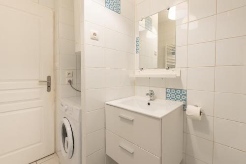 a white bathroom with a sink and a washing machine at Chalets De L’arriutort 2 - Laruns in Laruns