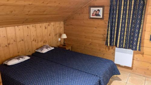 a bedroom with a blue bed in a cabin at Appartement Airelles B19 in Levassaix