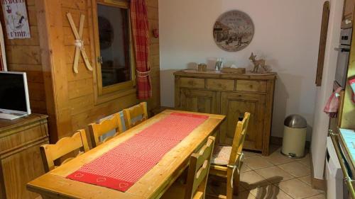 a dining room with a wooden table and chairs at Appartement Airelles B19 in Levassaix