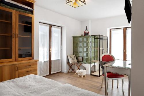a bedroom with a bed and a desk and chairs at Bnb and Breakfast Pellizzano in Pellizzano