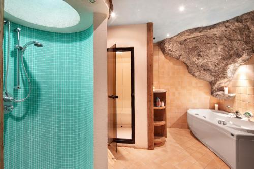 a bathroom with a shower and a tub and a sink at Chalet Royal in Livigno