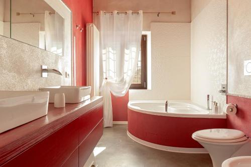 a bathroom with a tub and a toilet and a sink at Sunflowers Dimora in Cascina