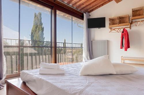 a bedroom with a bed and a large window at Sunflowers Dimora in Cascina